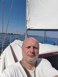 Man sailing on sailboat in sea against sky