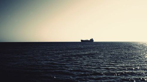 Boat sailing in sea against clear sky