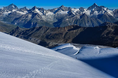 Scenic view of snowcapped mountains against blue sky