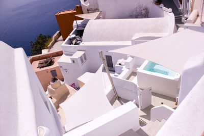 High angle view of tables and chairs outside house on sunny day