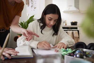 Mother assisting to girl doing homework