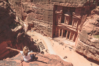 High angle view of woman with arms outstretched at al-khazneh