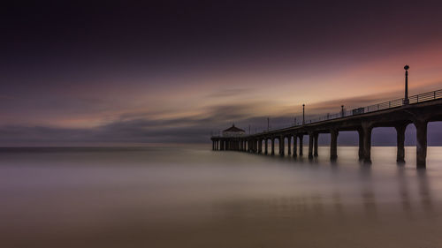 Pier on sea at sunset