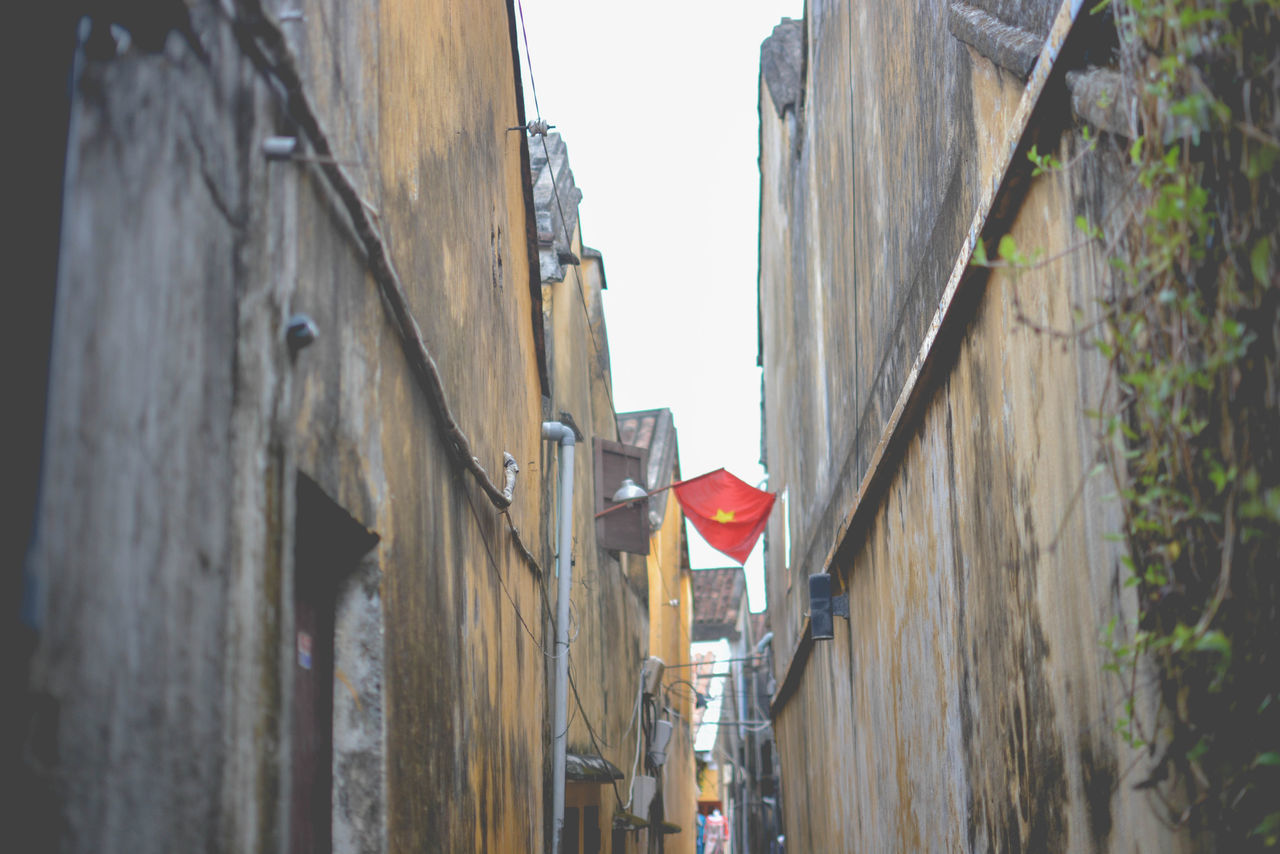 LOW ANGLE VIEW OF BUILDINGS IN NARROW ALLEY