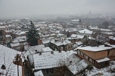 High angle view of snow covered houses in city