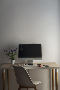 Overhead view of a workspace. we can see a computer, a smartphone, a notebook,, headphones, a keyboard, a pen, a red mouse, a plant, a 360-degree camera and a hard drive.