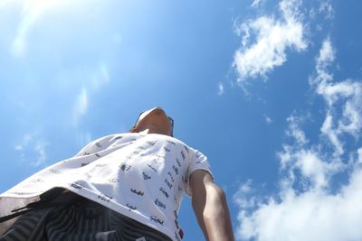 Low angle view of woman against blue sky