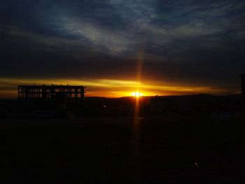 Silhouette buildings against sky during sunset