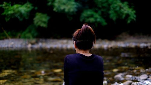 Rear view of woman by lake