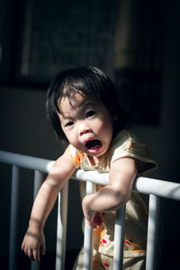 Portrait of cute baby girl in crib