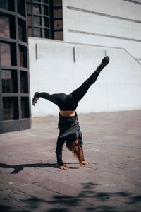 Full length of woman performing handstand