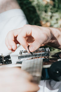 Cropped hand of man playing guitar