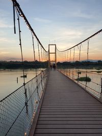 View of bridge over river at sunset