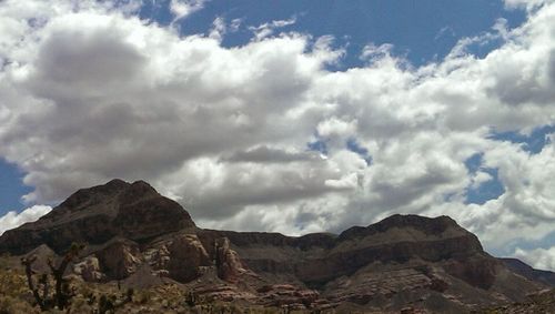 Scenic view of mountains against cloudy sky