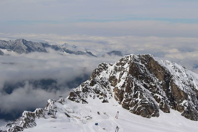 High angle view of snow covered mountain against cloudy sky