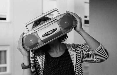 Portrait of girl holding camera at home