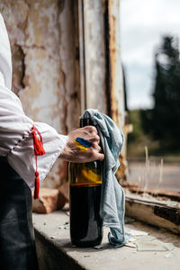 Midsection of man holding coffee