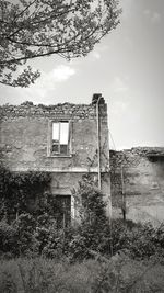 Abandoned building on field against sky