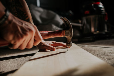 Man hammering nail into board