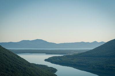 Scenic view of lake and mountains against clear sky