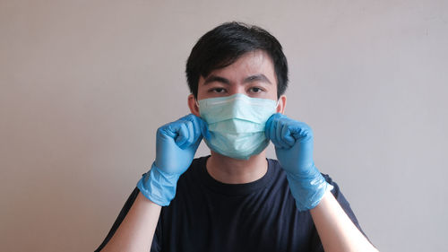 Portrait of teenage girl wearing mask against white background