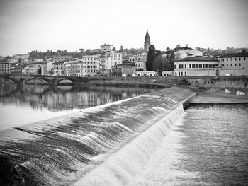 Bridge over river amidst buildings in city