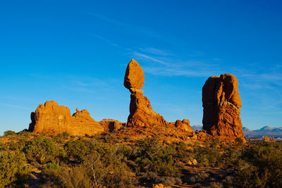 Rock formations on landscape against blue sky