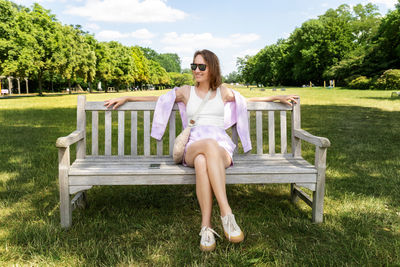 Young woman sitting on bench at park