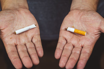 Midsection of person holding cigarette