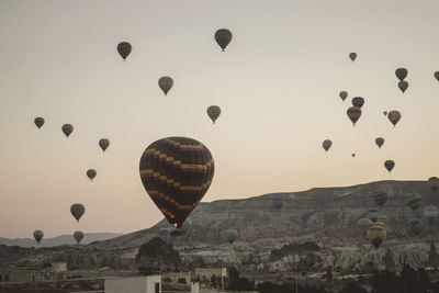 Low angle view of hot air balloons flying against sky during sunrise