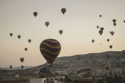 Low angle view of hot air balloons flying against sky during sunset