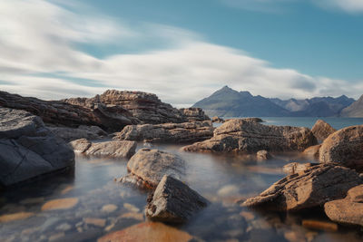 Scenic view of sea and mountains against sky