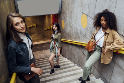 Young women staring while standing on staircase