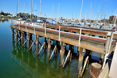 Boats moored at harbor against clear sky