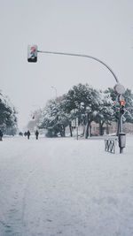 Overhead cable car on snow covered street against sky