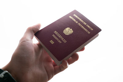 Close-up of hand holding text against white background