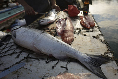 Midsection of fisherman cutting fish at table