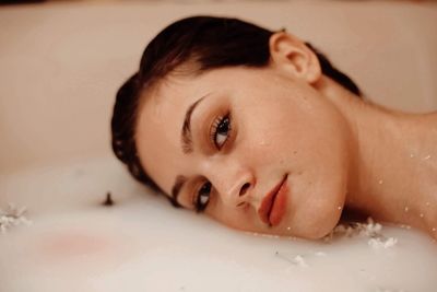 Portrait of beautiful woman taking bath in bathtub