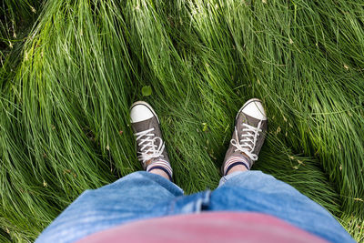 Low section of woman standing on field