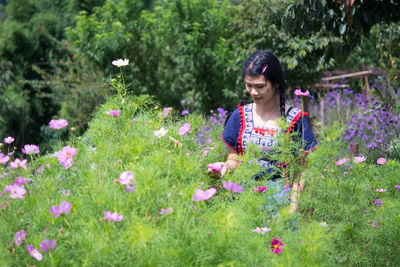 Woman sitting on pink flowering plants