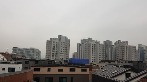 Buildings in city against clear sky