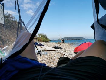 Low section of man relaxing on beach