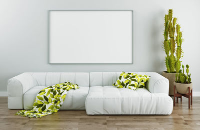 Potted plants on sofa against wall at home