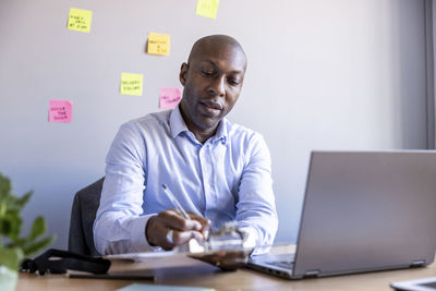 Man using mobile phone while sitting on table