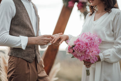 Midsection of woman holding flower bouquet