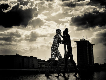 People standing against sky in city