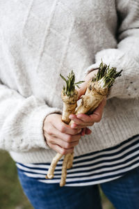 Midsection of woman holding plant