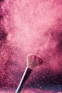 Close-up of pink umbrella against colored background