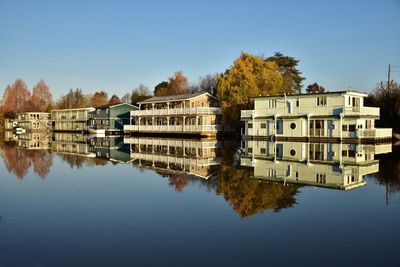 Reflection of trees in water against clear sky