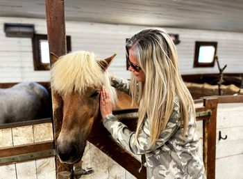 Woman with horse in stable